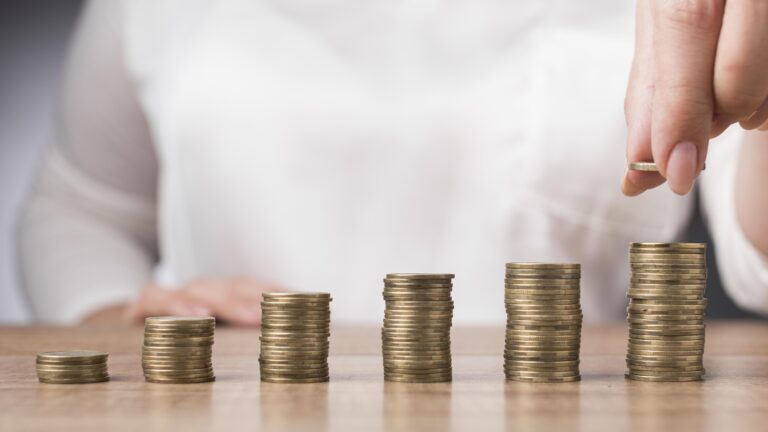 woman-placing-coin-pile-coins